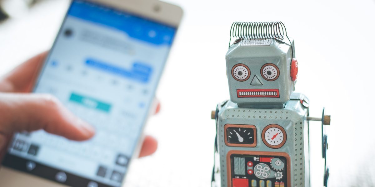 Image of Robot and Smartphone with blurred out SMS